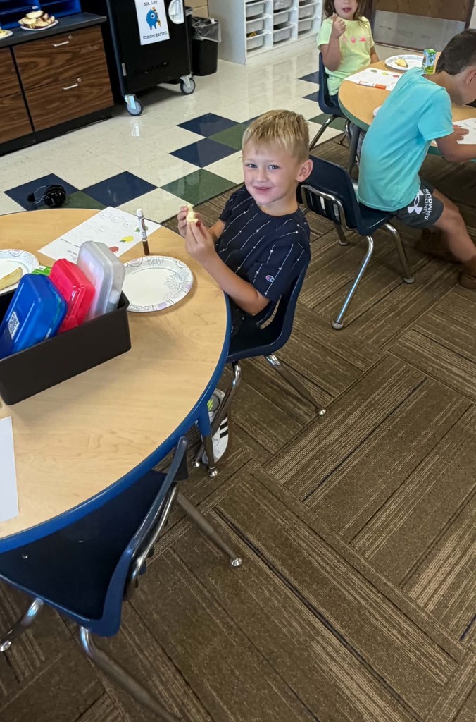 Children sitting at a table giving thumbs up or down