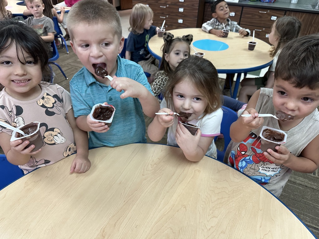 A group of kids eating chocolate pudding
