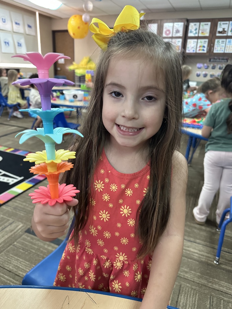 Little girl holding a flower tower made of lots of colors