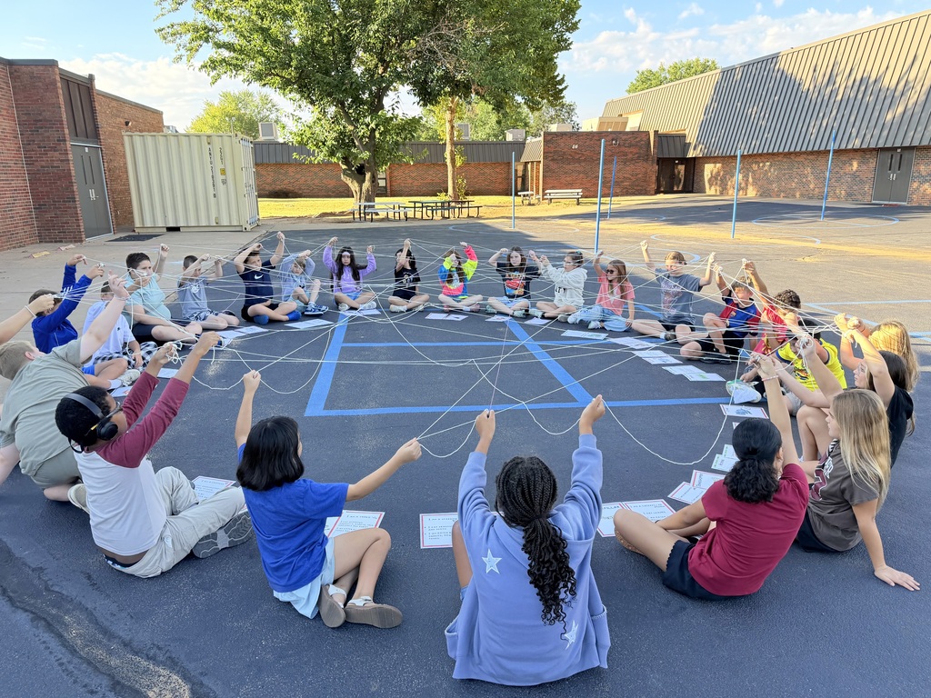 5th grade doing a science experiment outside. Students created a food wed using yarn.