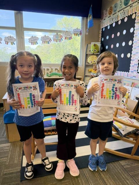 Students posing with dot sticker charts