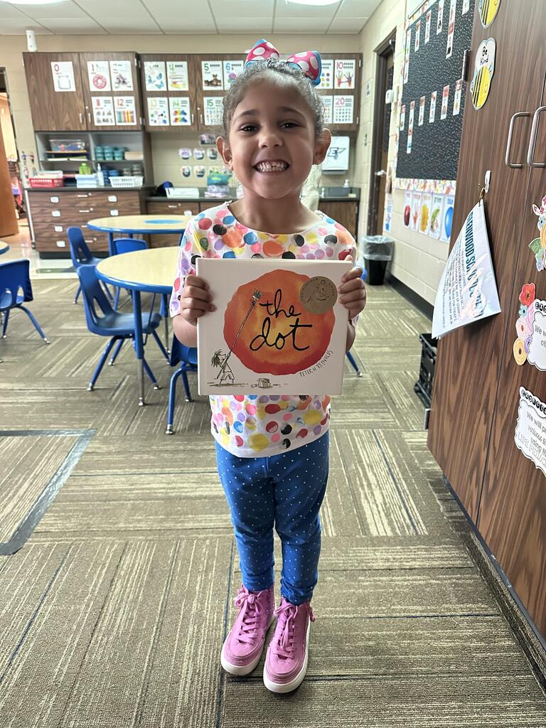 Little girl holding The Dot book