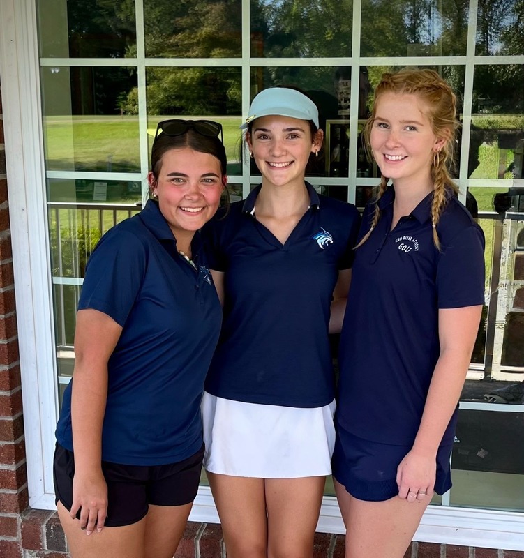 three children with golf clothing on