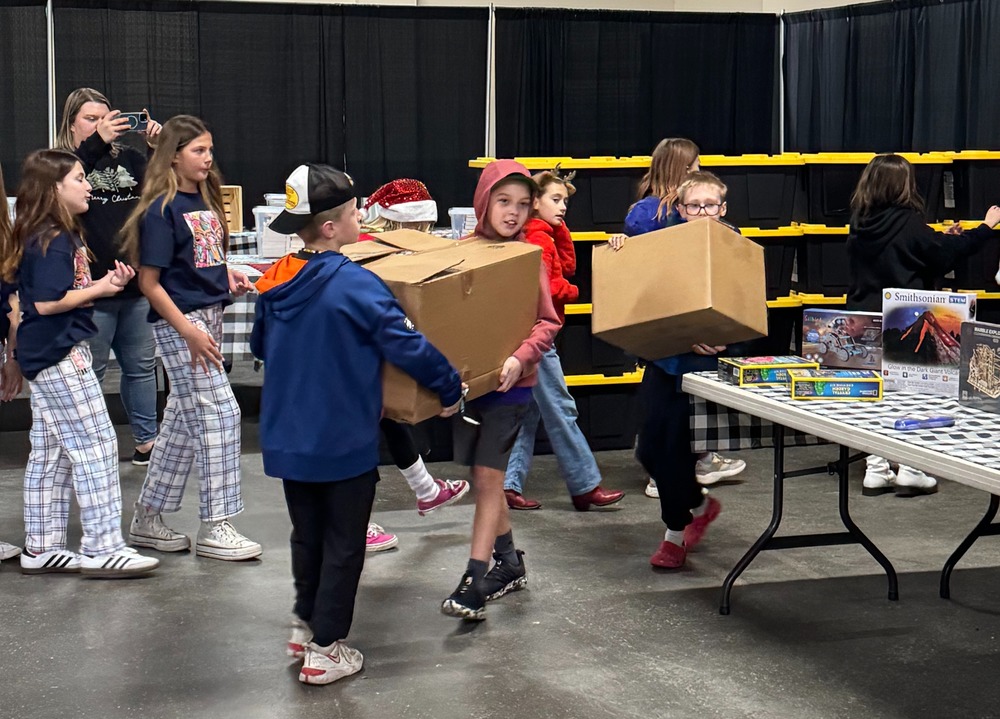 Sunrise leadership student carrying boxes in the Expo center hall