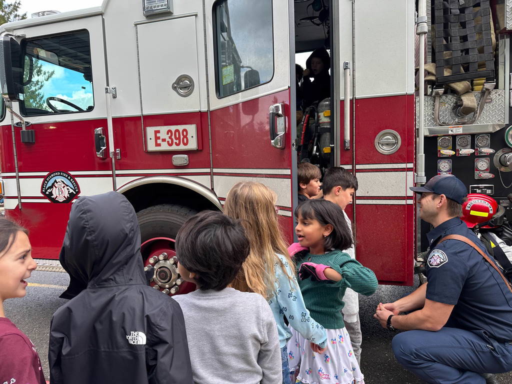 Students enjoying time visiting the firetruck and firefighters.