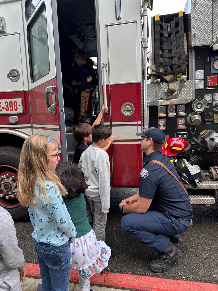 Students enjoying time visiting the firetruck and firefighters.