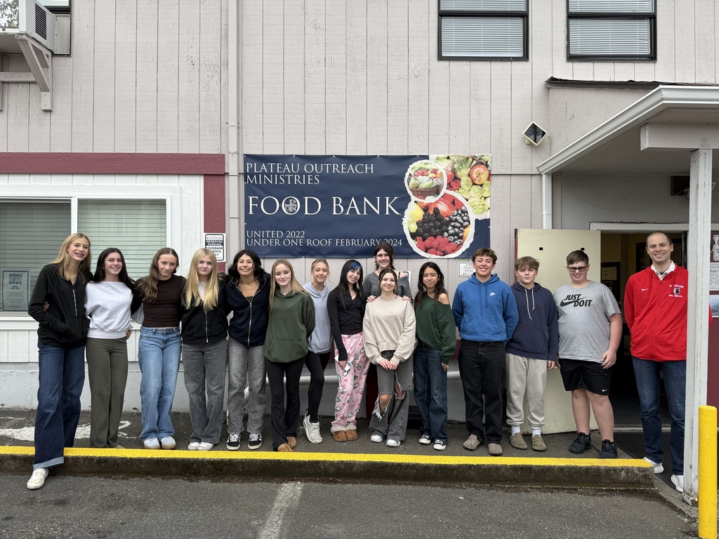EMS students and their teacher posing for a group photo in front of the food bank