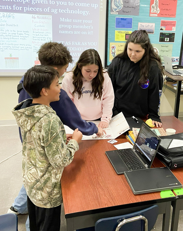 middle school students gathered around a FFA project