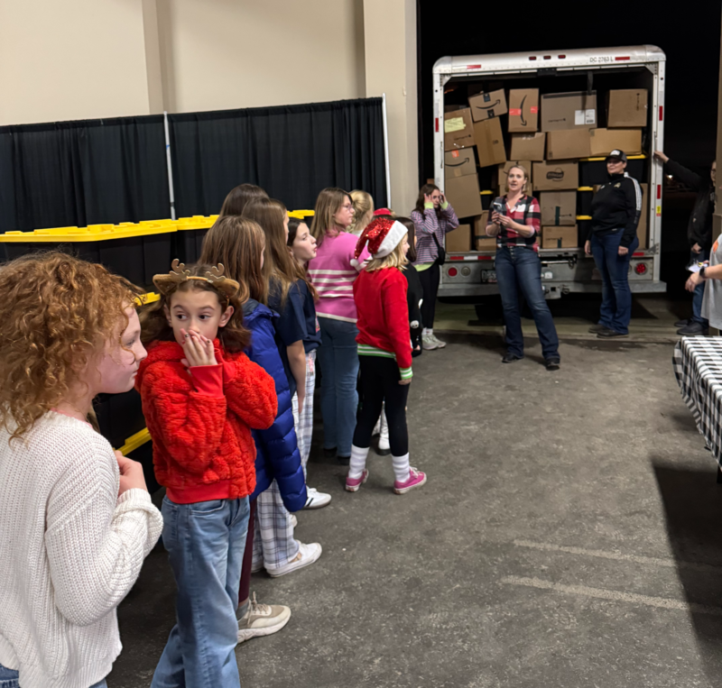 students waiting to unload boxes from a box truck