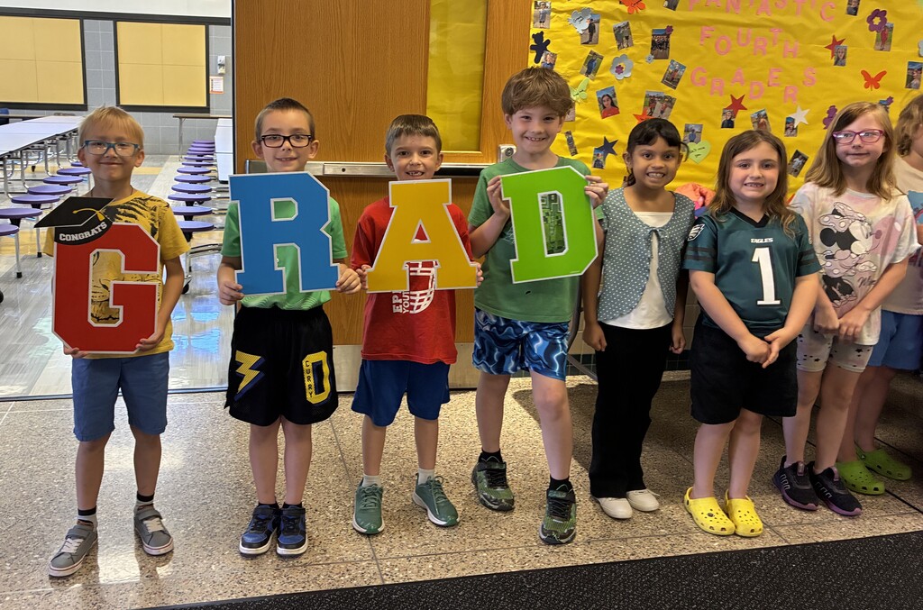 Elementary students with graduation sign
