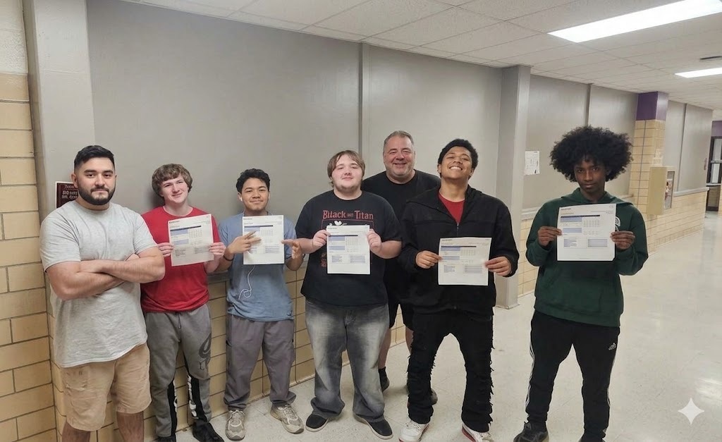 Photo of Erie High Auto Body senior students proudly holding up their NOCTI testing certificates, celebrating their hard work and advanced-level achievement.