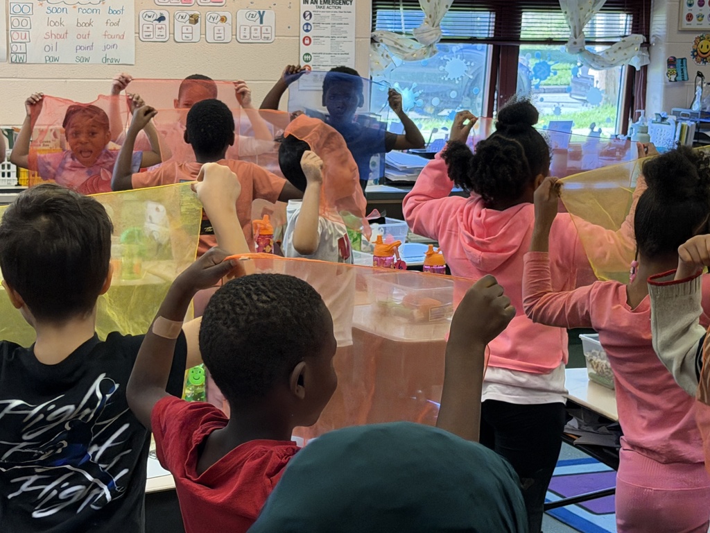 Students holding colorful mesh to their faces to see through.