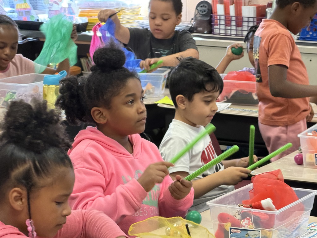 Students playing with musical sticks. 
