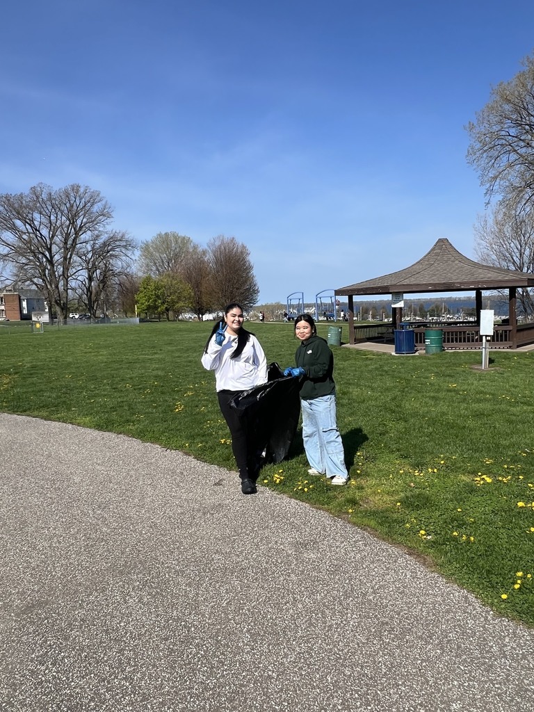 Photo of two Erie High students at Bayview Park carrying a garbage bag during park clean up.