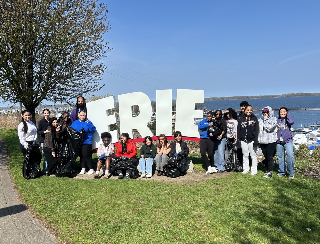Group photo of Erie High Students and Erie High community school directors in front of the Erie sign at Bayview park.
