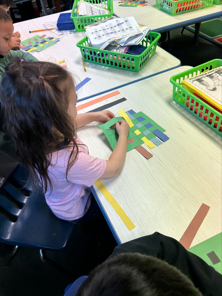 Student practicing weaving with paper.
