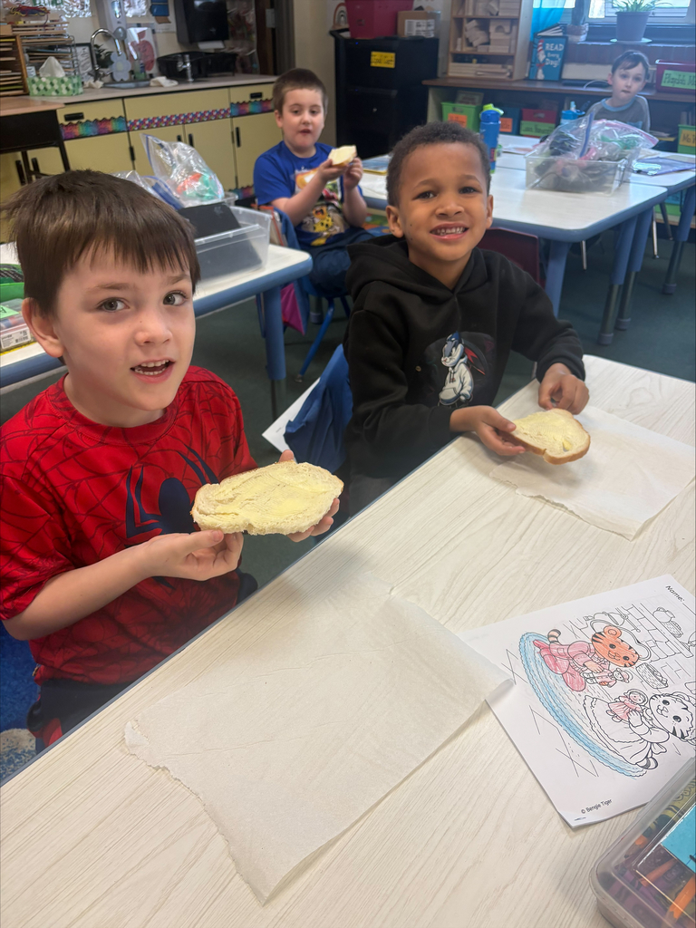 Student enjoying butter they made on a piece of bread.