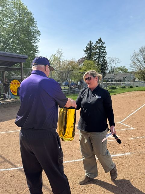 A women giving  a man a gift bag. 