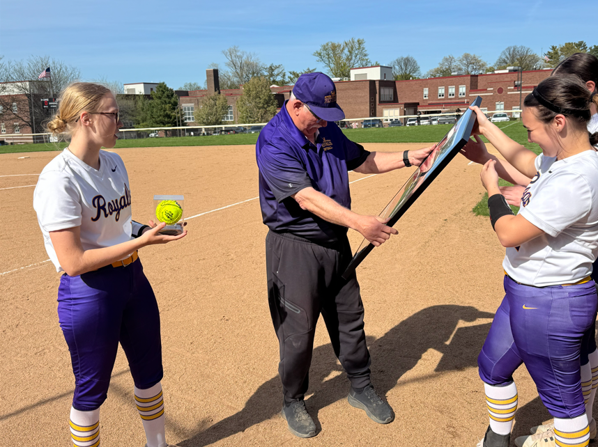 Erie High Royals Softball girls giving their coach a frame and ball. 