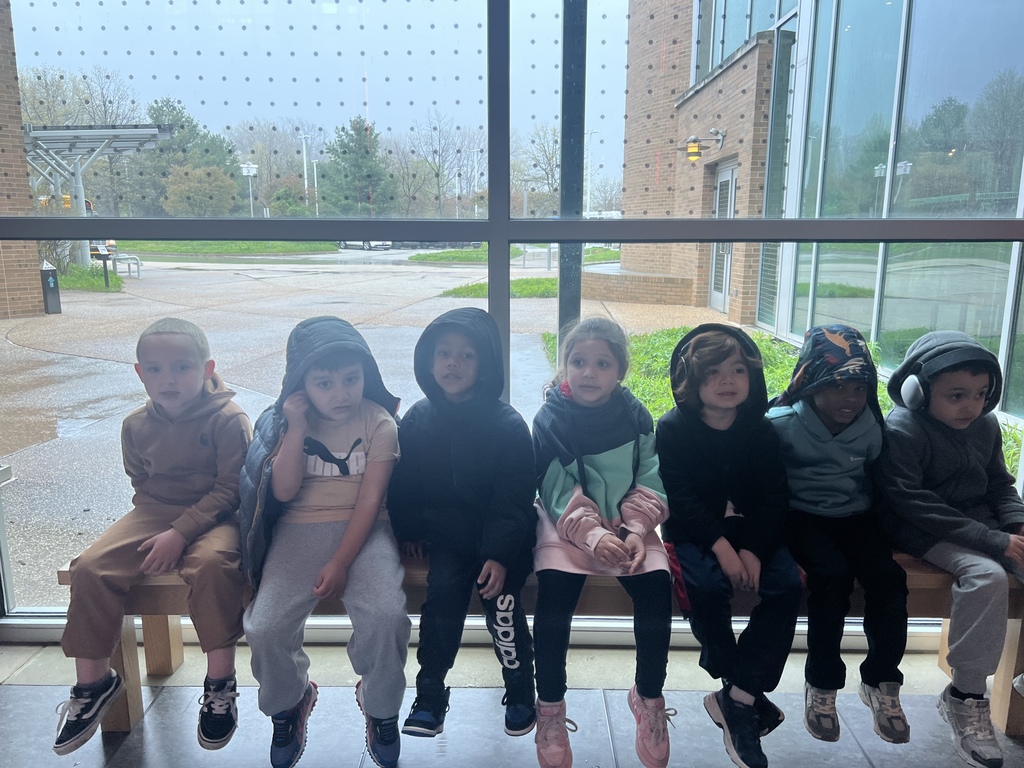 students sitting on a bench at the tom ridge center on their field trip today. 