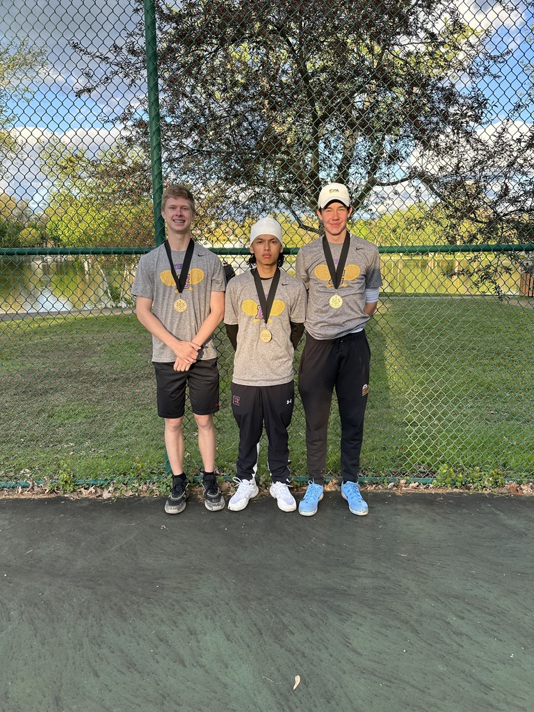 Three young men are posing with medals around their necks. 