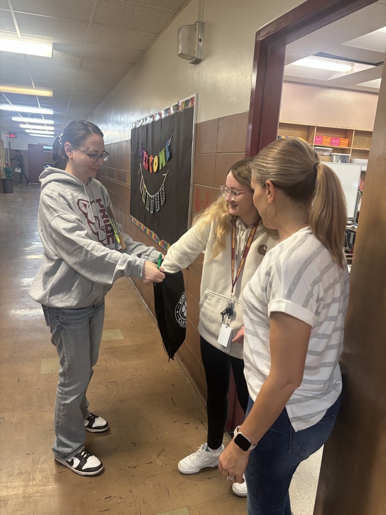 Two teachers picking gift cards from bag from PTSA