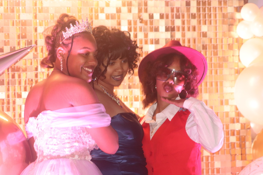 Erie High students taking photos in front of prom backdrop. 