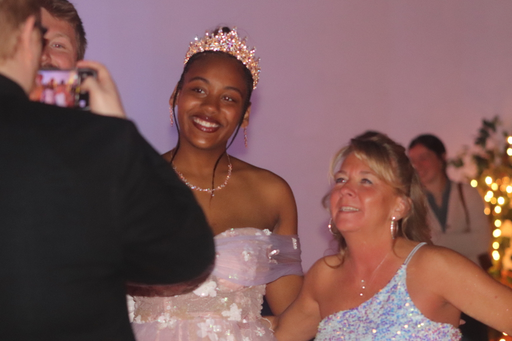 Erie High Prom Court student taking a photo with Ms. Nikolai. 