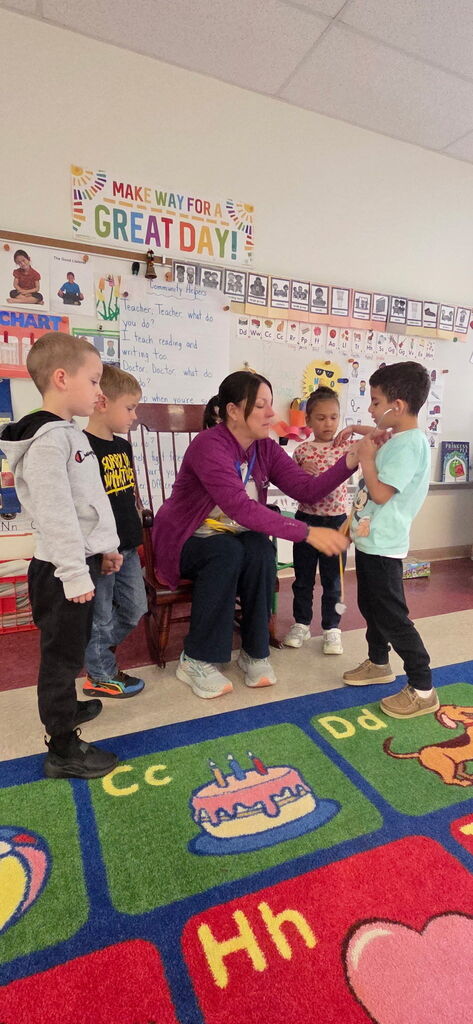 Community health partner, practicing on students with stethoscope