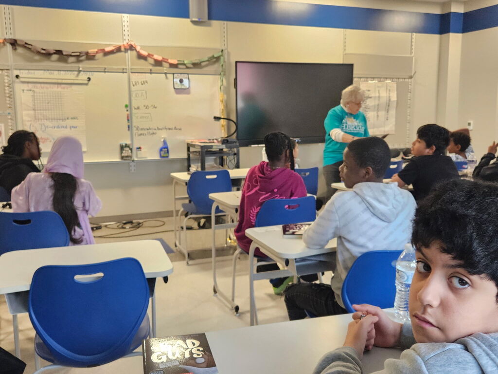Edison students being read to by a Hooked on Books for Kids volunteer.