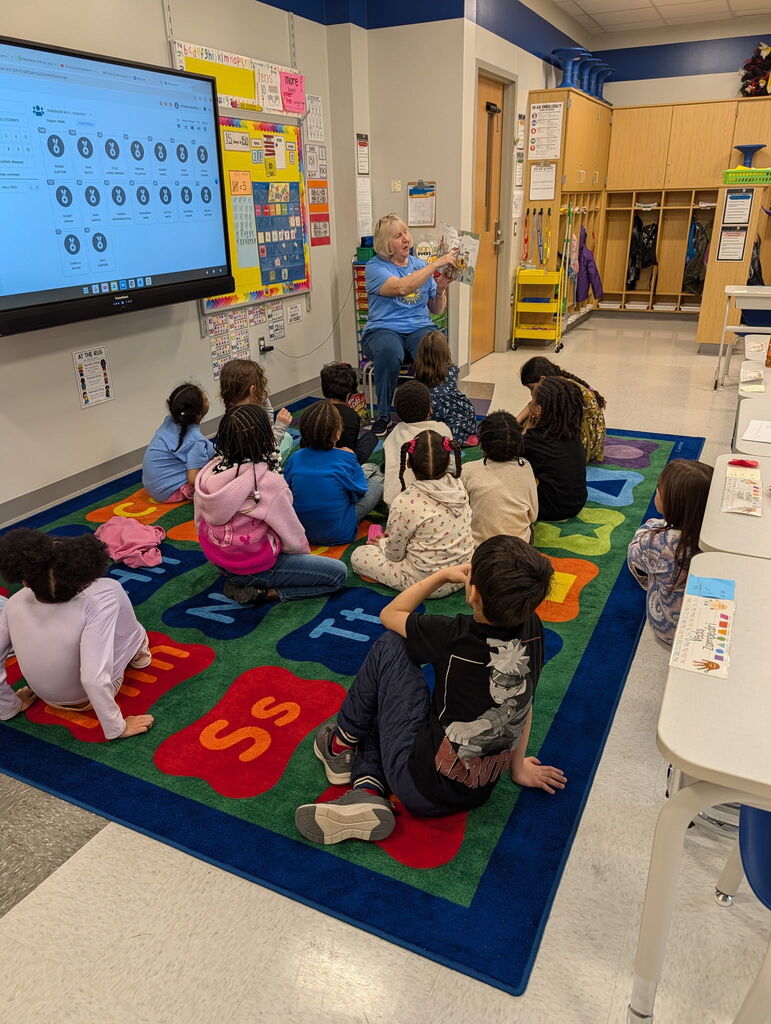 Edison students being read to by a Hooked on Books for Kids volunteer.