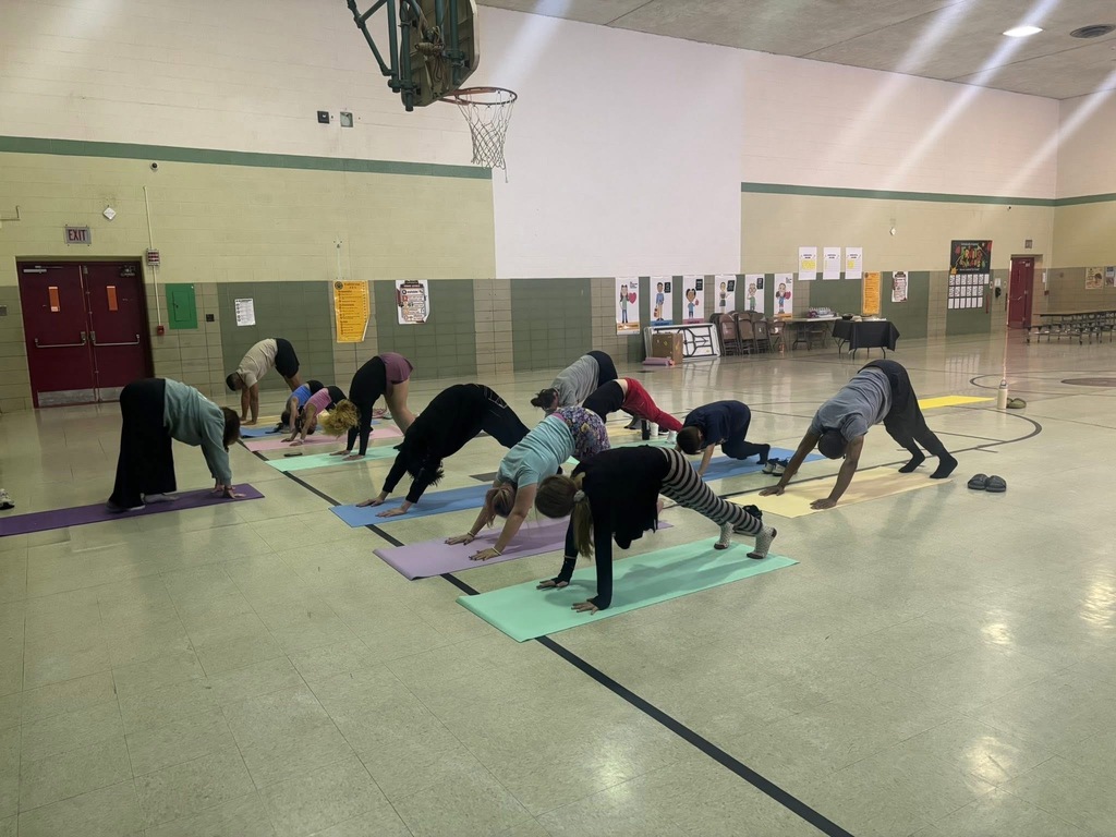 Group of Grover families doing yoga together in gym