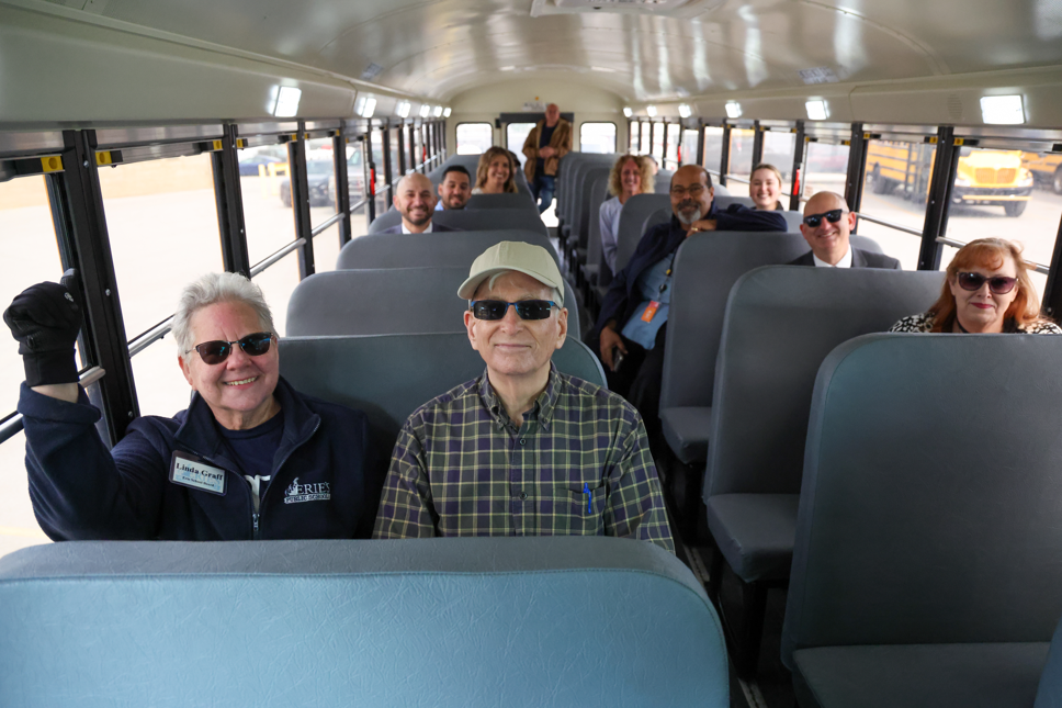 People sitting in the new electric school buses.