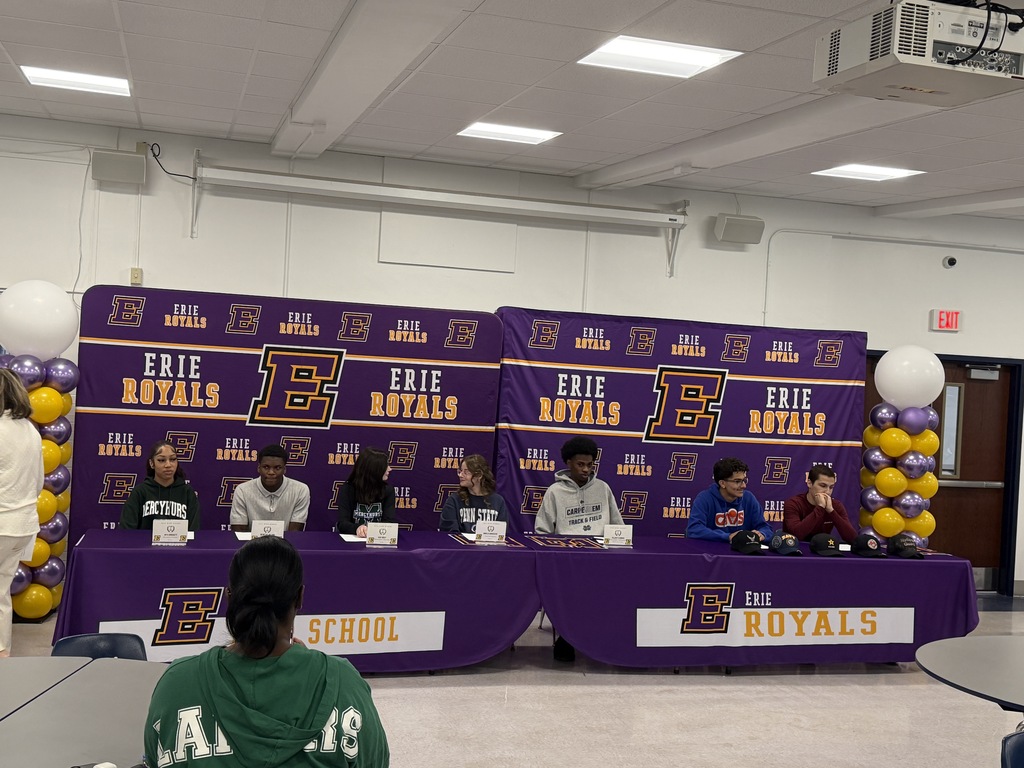 Students sitting in front of an Erie Royals backdrop.