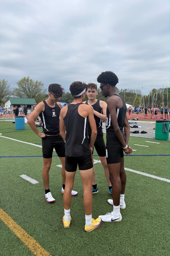 Erie High School track and field students huddled and talking. 