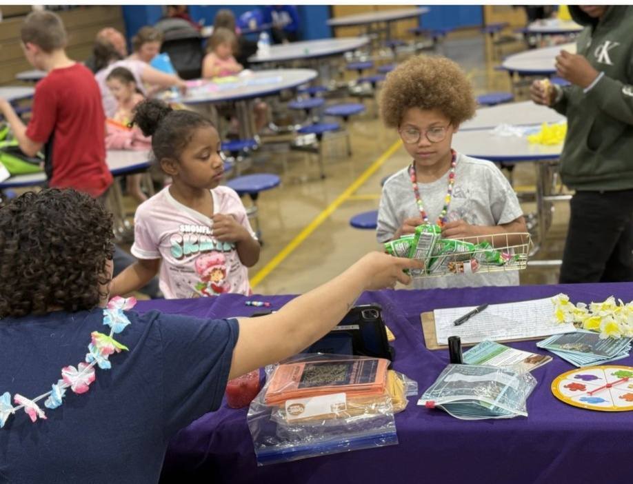 students choosing art kit at summer resource fair craft table