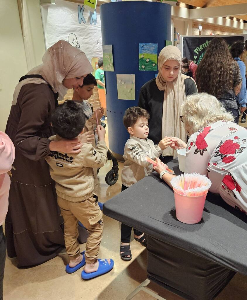 family and volunteer at summer resource fair