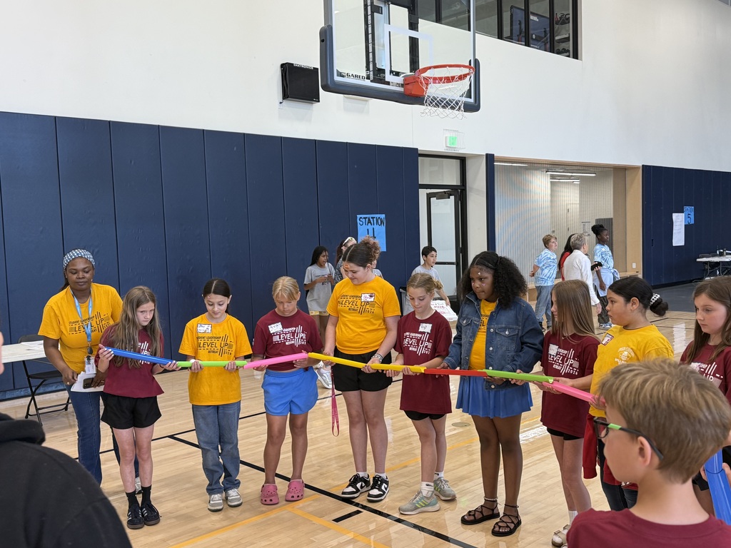 Edison students playing a game where they work as a team to make a ball to flow through open tubes as far as they can.