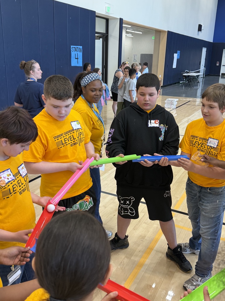Edison students playing a game where they work as a team to make a ball to flow through open tubes as far as they can.