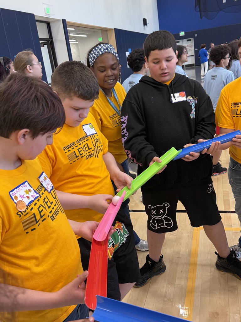 Edison students playing a game where they work as a team to make a ball to flow through open tubes as far as they can.