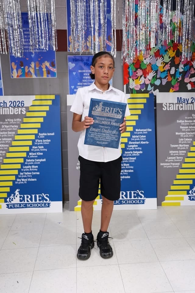 A student posing while holding their Stairclimber award.