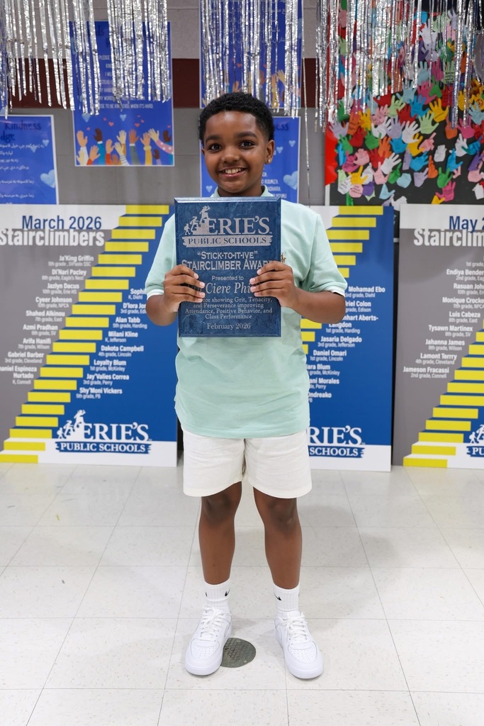 A student posing while holding their Stairclimber award.