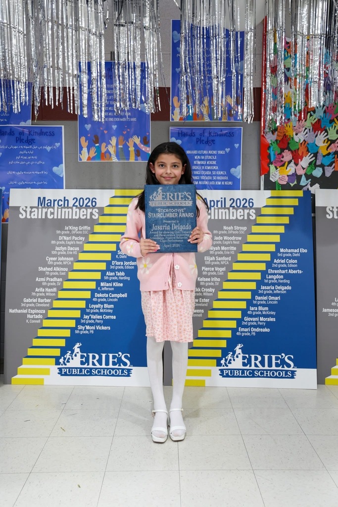 A student posing while holding their Stairclimber award.