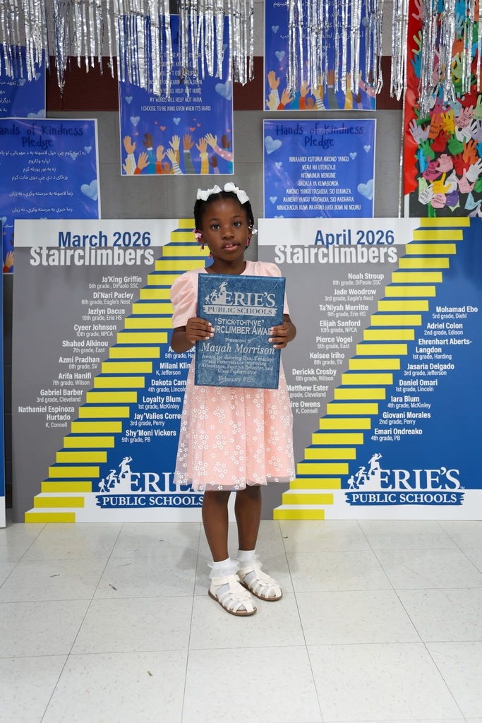 A student posing while holding their Stairclimber award.