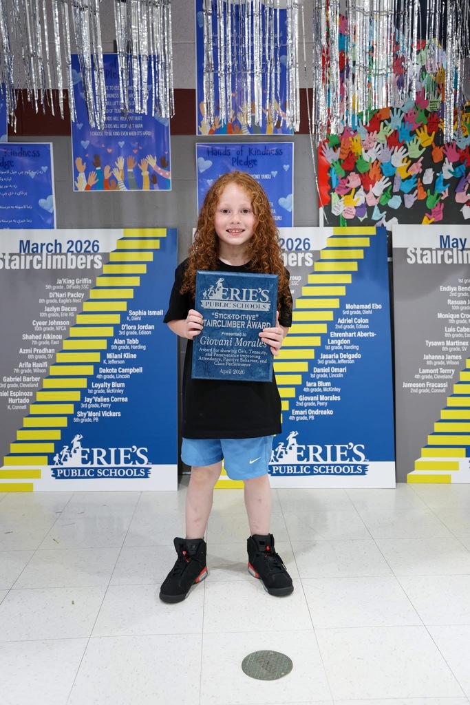 A student posing while holding their Stairclimber award.