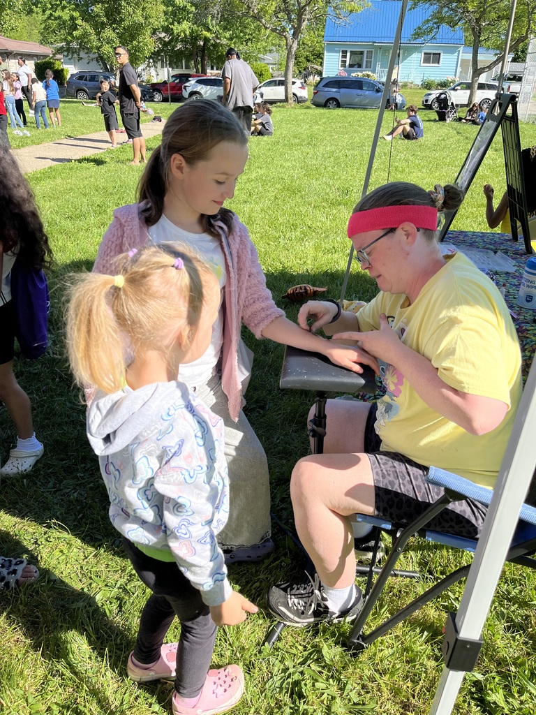 Two students getting glitter tattoos.