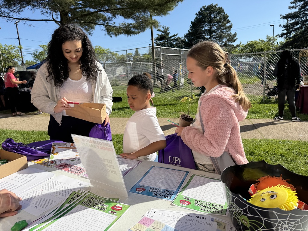 Family at an information station looking through resources.