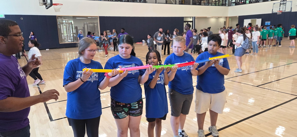 Ambassadors working together to roll a ball through open topped tubes.