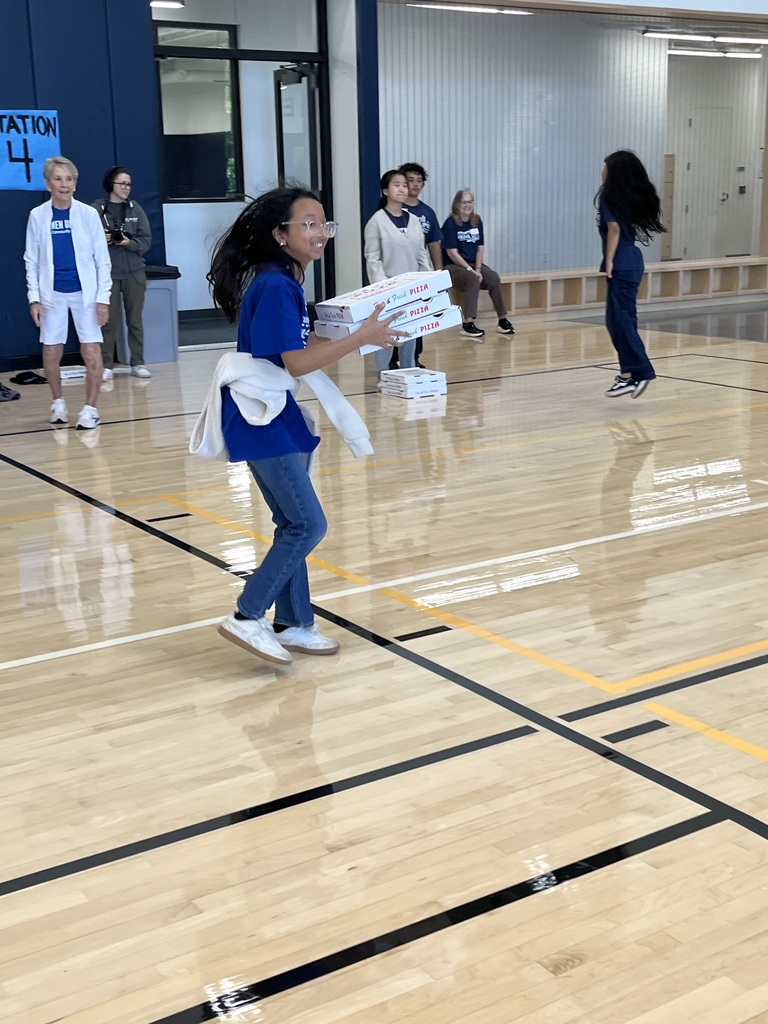 Student running in the pizza box relay.