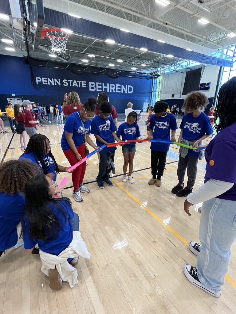 Ambassadors working together to roll a ball through open topped tubes.